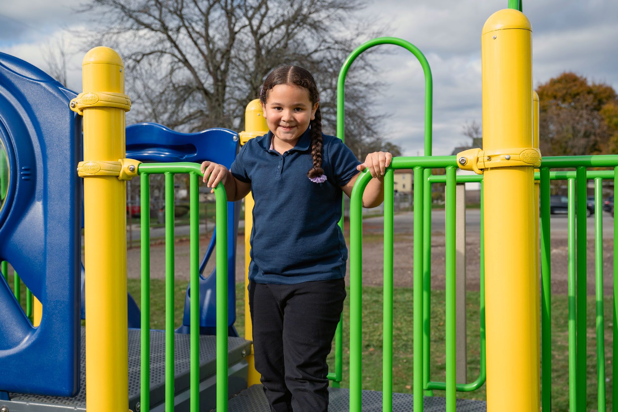 Smiling student on a playground structure.